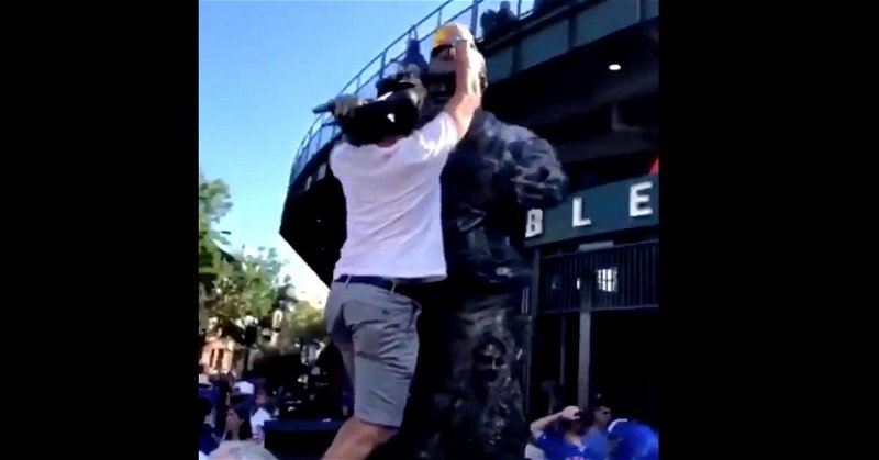 A brazen young man climbed onto the Harry Caray statue at Wrigley Field in order to place a hard hat on its head.