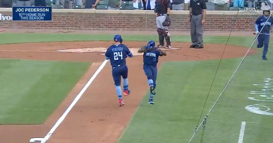 Joc Pederson and third-base coach Willie Harris celebrated Pederson's leadoff jack on the basepaths.