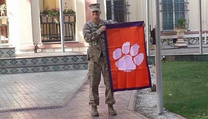 Capt. Trey Kennedy shows off the Clemson flag in front of US/NATO headquarters in Kabul 