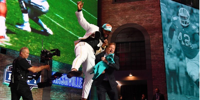Christian Wilkins tries to cheat bump the NFL Commissioner at the NFL Draft.  (Christopher Hanewinc / USAT)